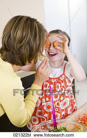 mother and daughter having fun with carrot slices in kitchen View Large Photo Image Stock Image - mother and daughter having fun with carrot slices in kitchen. Fotosearch