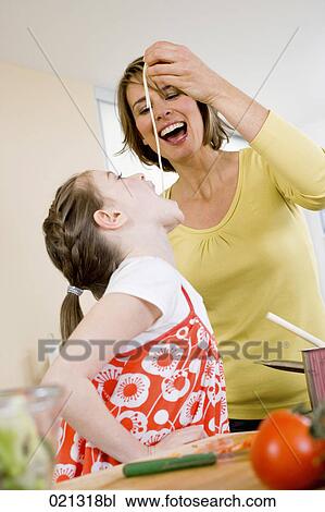mother feeding her daughter spaghetti View Large Photo Image Stock Image - mother feeding her daughter spaghetti. Fotosearch