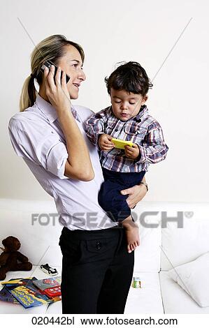 mother holding little son and talking on mobile phone View Large Photo Image Stock Image - mother holding little son and talking on mobile phone. Fotosearch