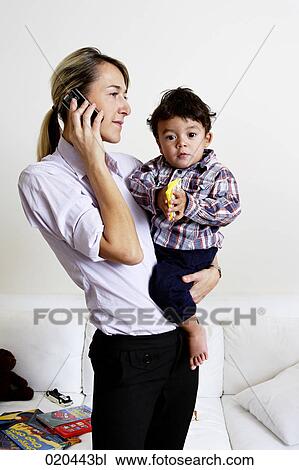 mother holding little son and talking on mobile phone View Large Photo Image Stock Image - mother holding little son and talking on mobile phone. Fotosearch