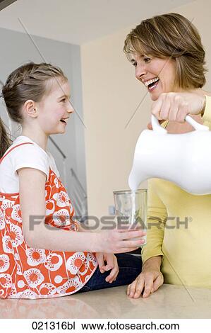 mother pouring milk into her daughter´s glass View Large Photo Image Stock Image - mother pouring milk into her daughter´s glass. Fotosearch