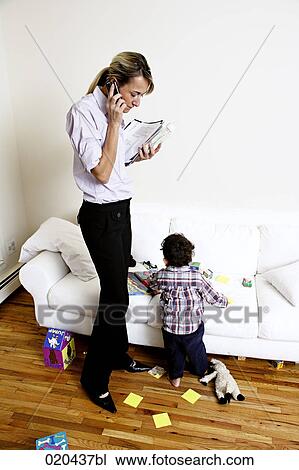 mother sitting on sofa talking on mobile phone while child is playing View Large Photo Image Stock Image - mother sitting on sofa talking on mobile phone while child is playing. Fotosearch