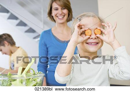 mother watching daughter playing with carrot slices in kitchen View Large Photo Image Stock Image - mother watching daughter playing with carrot slices in kitchen. Fotosearch
