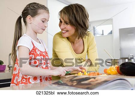 mother watching her daughter cutting vegetables View Large Photo Image Stock Image - mother watching her daughter cutting vegetables. Fotosearch