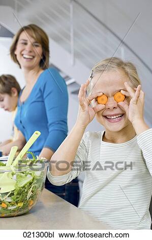 mother watching her daughter making fun with carrot slices View Large Photo Image Stock Image - mother watching her daughter making fun with carrot slices. Fotosearch