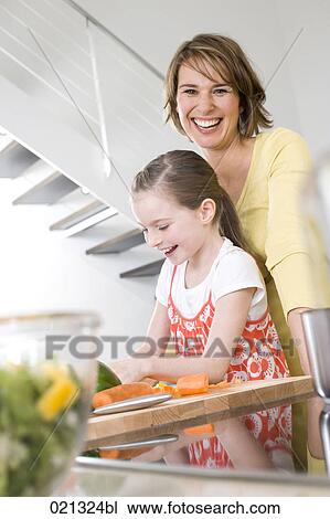 mother watching over her daughter cutting vegetables View Large Photo Image Stock Image - mother watching over her daughter cutting vegetables. Fotosearch