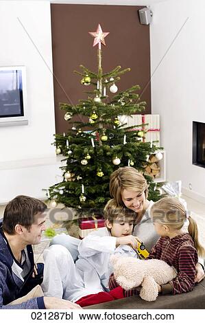 parents sitting with their children on sofa on christmas morning View Large Photo Image Stock Image - parents sitting with their children on sofa on christmas morning. Fotosearch