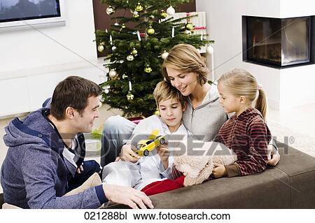 parents sitting with their children on sofa on christmas morning View Large Photo Image Stock Image - parents sitting with their children on sofa on christmas morning. Fotosearch