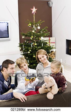 parents sitting with their children on sofa on christmas morning View Large Photo Image Stock Image - parents sitting with their children on sofa on christmas morning. Fotosearch