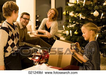 parents watching their children opening christmas presents on christmas eve View Large Photo Image Stock Image - parents watching their children opening christmas presents on christmas eve. Fotosearch
