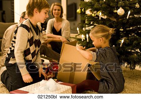 parents watching their children opening christmas presents on christmas eve View Large Photo Image Stock Image - parents watching their children opening christmas presents on christmas eve. Fotosearch