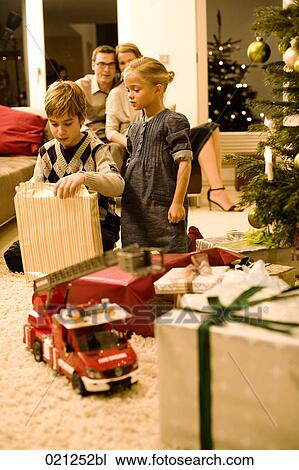 parents watching their children opening christmas presents on christmas eve View Large Photo Image Stock Image - parents watching their children opening christmas presents on christmas eve. Fotosearch