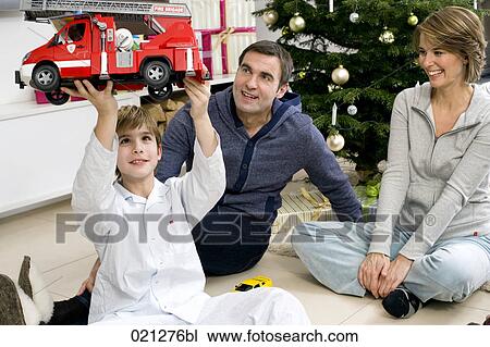 parents watching their son play with toy car on christmas morning View Large Photo Image Stock Image - parents watching their son play with toy car on christmas morning. Fotosearch
