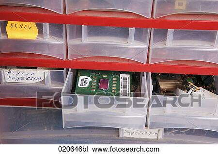 Stock Image - plastic cupboard with spare parts at computer workshop. Fotosearch