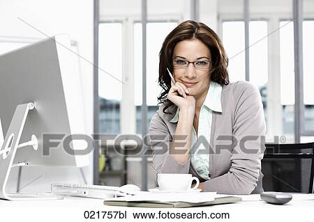 portrait of businesswoman sitting at desk View Large Photo Image Stock Image - portrait of businesswoman sitting at desk. Fotosearch