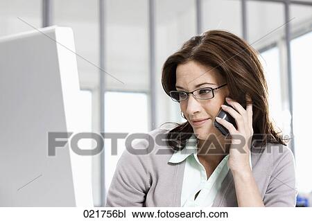 portrait of businesswoman talking on telephone and looking at computer screen View Large Photo Image Stock Image - portrait of businesswoman talking on telephone and looking at computer screen. Fotosearch