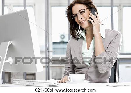 portrait of businesswoman talking on telephone and looking at computer screen View Large Photo Image Stock Image - portrait of businesswoman talking on telephone and looking at computer screen. Fotosearch