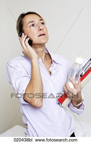 portrait of businesswoman with mobile phone holding documents and baby bottle View Large Photo Image Stock Image - portrait of businesswoman with mobile phone holding documents and baby bottle. Fotosearch