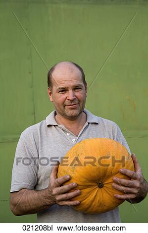 portrait of farmer holding pumpkin View Large Photo Image Stock Image - portrait of farmer holding pumpkin. Fotosearch