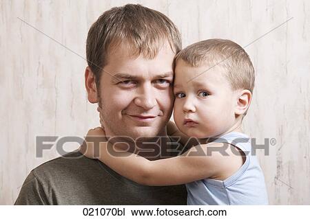 Stock Image - portrait of father holding his young son. Fotosearch
