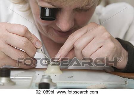 Stock Image - portrait of female watchmaker at work. Fotosearch