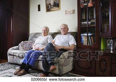portrait of mature couple sitting on sofa at home View Large Photo Image Stock Image - portrait of mature couple sitting on sofa at home. Fotosearch