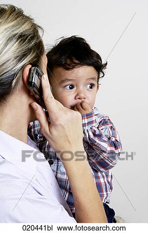 portrait of toddler held by mother talking on mobile phone View Large Photo Image Stock Image - portrait of toddler held by mother talking on mobile phone. Fotosearch