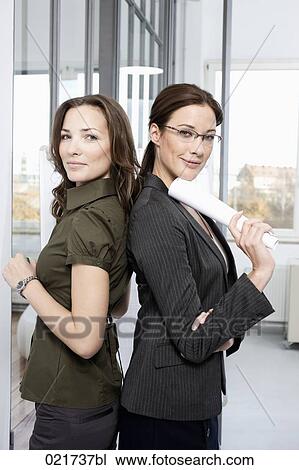 portrait of two businesswomen standing back to back View Large Photo Image Stock Image - portrait of two businesswomen standing back to back. Fotosearch