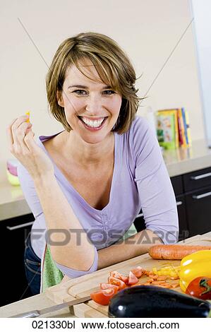 Stock Image - portrait of woman in kitchen. Fotosearch