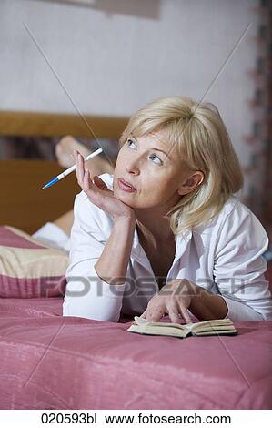 portrait of woman lying on bed looking at diary View Large Photo Image Stock Image - portrait of woman lying on bed looking at diary. Fotosearch