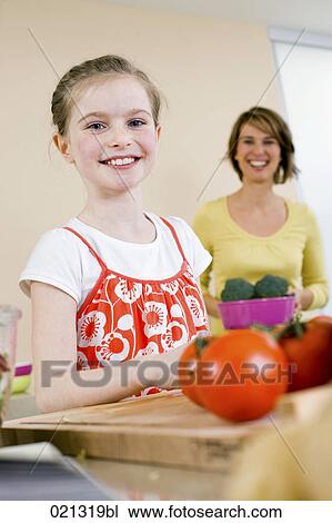 portrait of young girl helping her mother in kitchen View Large Photo Image Stock Image - portrait of young girl helping her mother in kitchen. Fotosearch