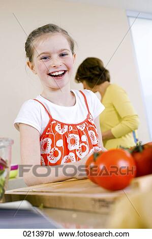Stock Image - portrait of young girl in kitchen. Fotosearch