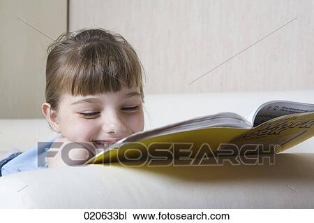 portrait of young girl on sofa reading book View Large Photo Image Stock Image - portrait of young girl on sofa reading book. Fotosearch
