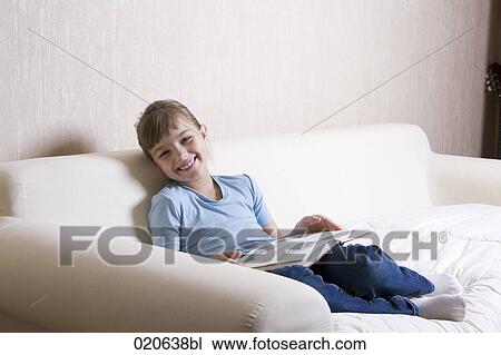 portrait of young girl on sofa reading book View Large Photo Image Stock Image - portrait of young girl on sofa reading book. Fotosearch