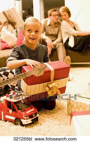 portrait of young girl opening present on christmas eve View Large Photo Image Stock Image - portrait of young girl opening present on christmas eve. Fotosearch