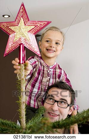 portrait of young girl putting star on top of christmas tree View Large Photo Image Stock Image - portrait of young girl putting star on top of christmas tree. Fotosearch