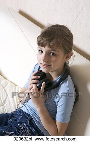 portrait of young girl sitting on sofa with earphones View Large Photo Image Stock Image - portrait of young girl sitting on sofa with earphones. Fotosearch