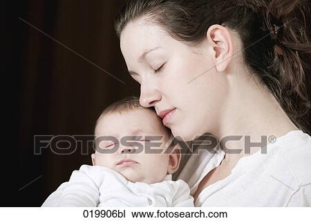 portrait of young mother holding her sleeping baby girl View Large Photo Image Stock Image - portrait of young mother holding her sleeping baby girl. Fotosearch