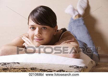 portrait of young woman at home lying on cushion View Large Photo Image Stock Image - portrait of young woman at home lying on cushion. Fotosearch