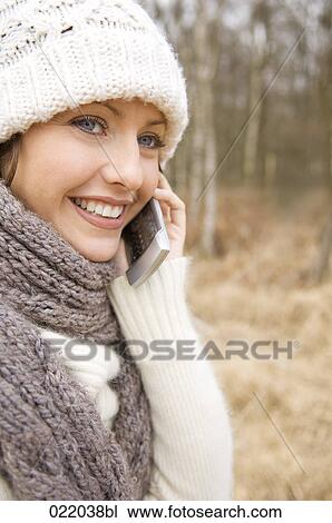 Stock Image - portrait of young woman in autumn talking on mobile phone. Fotosearch