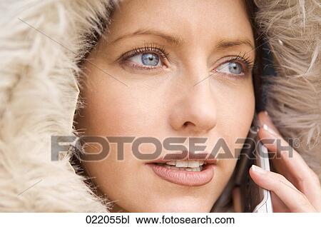 Stock Image - portrait of young woman in autumn talking on mobile phone. Fotosearch