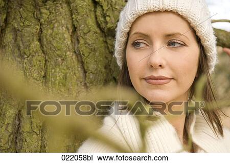 portrait of young woman in autumn leaning against tree View Large Photo Image Stock Image - portrait of young woman in autumn leaning against tree. Fotosearch