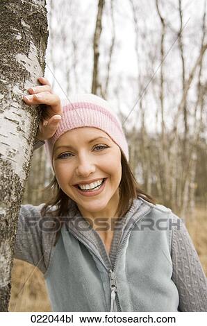 portrait of young woman leaning against tree in autumn View Large Photo Image Stock Image - portrait of young woman leaning against tree in autumn. Fotosearch