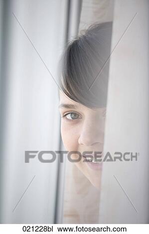 portrait of young woman standing at window View Large Photo Image Stock Image - portrait of young woman standing at window. Fotosearch