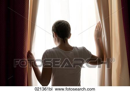 rear view of woman looking out of window View Large Photo Image Stock Image - rear view of woman looking out of window. Fotosearch