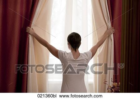 rear view of woman opening curtains View Large Photo Image Stock Image - rear view of woman opening curtains. Fotosearch