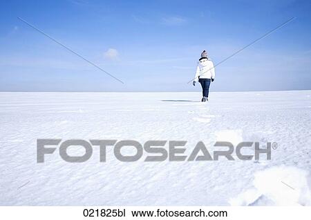 rear view of young woman walking through snow View Large Photo Image Stock Image - rear view of young woman walking through snow. Fotosearch