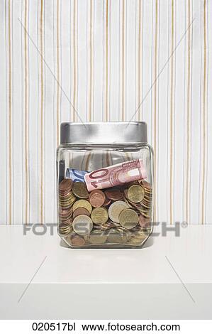 Stock Image - still life of money in jar on shelf. Fotosearch