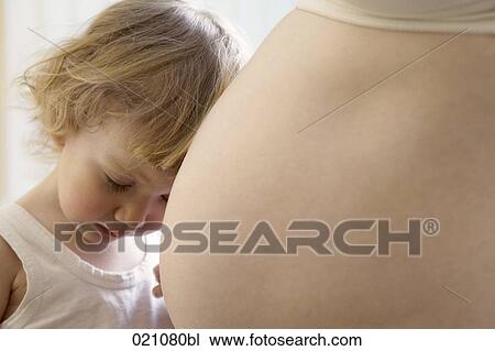 sulking young boy touching belly of pregnant mother View Large Photo Image Stock Image - sulking young boy touching belly of pregnant mother. Fotosearch