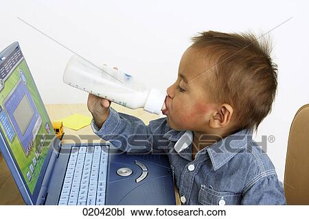 toddler sitting in front of toy laptop drinking from baby bottle View Large Photo Image Stock Image - toddler sitting in front of toy laptop drinking from baby bottle. Fotosearch